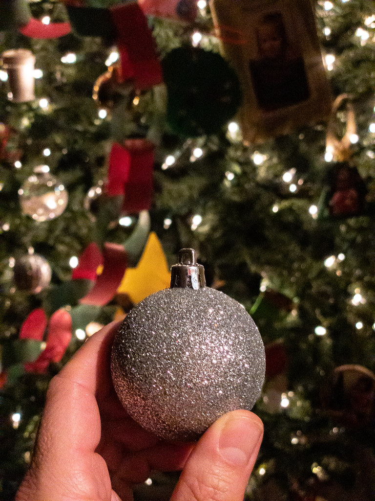 Boule de Noël devant un sapin illuminé